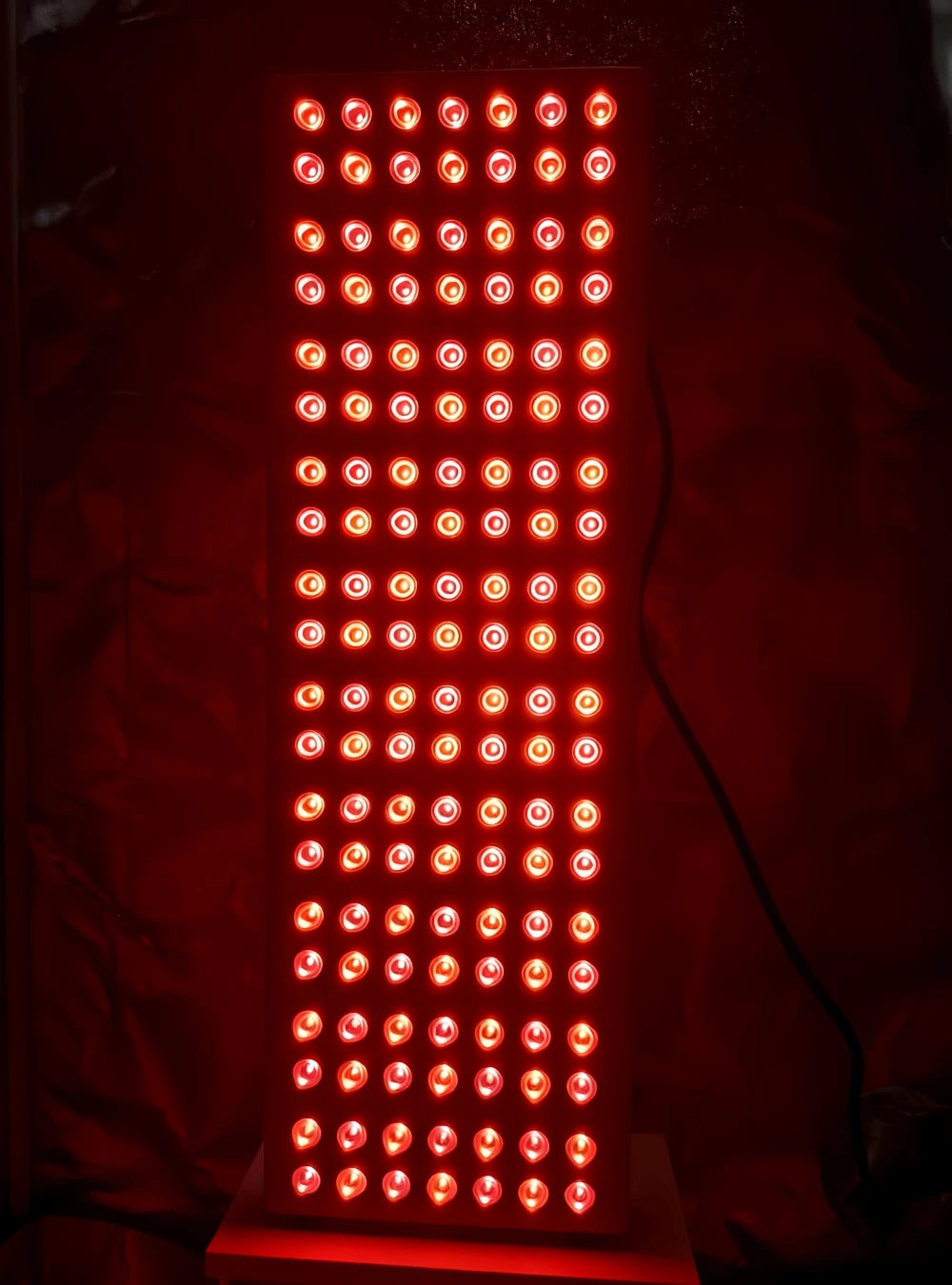 Red light therapy panel with LED bulbs for pain relief and skin rejuvenation, emitting 660nm and 850nm light therapy.