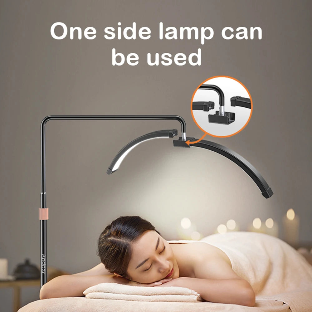 Black, adjustable half-moon floor lamp providing focused light for spa treatments, showing one removable light arm.