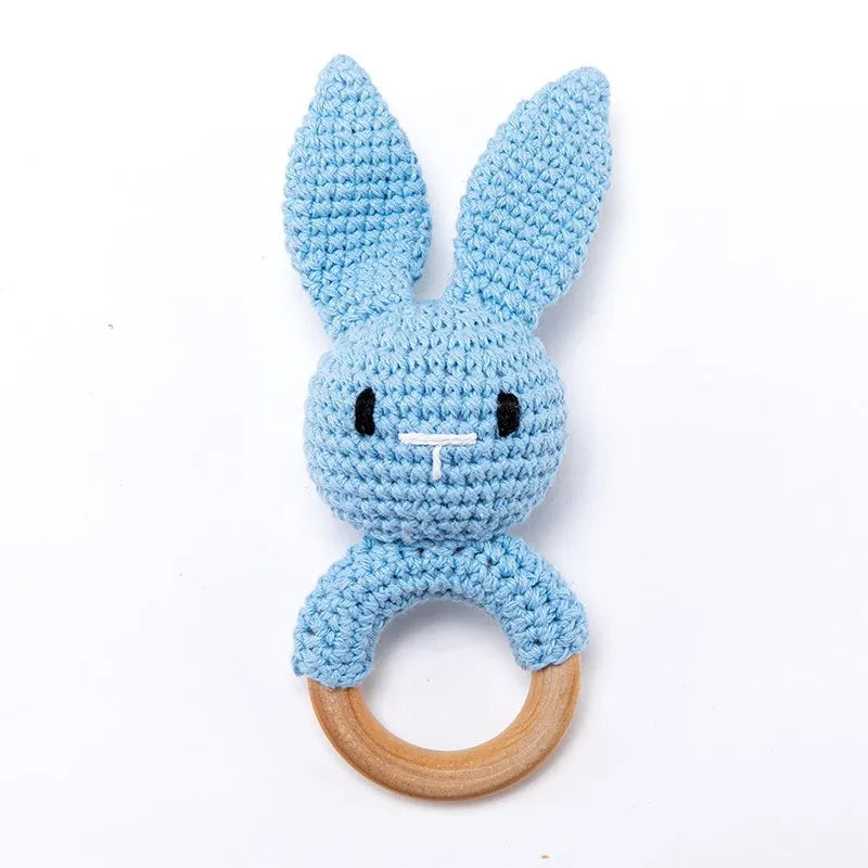 Blue crochet bunny baby teething ring with a natural wooden teether toy.