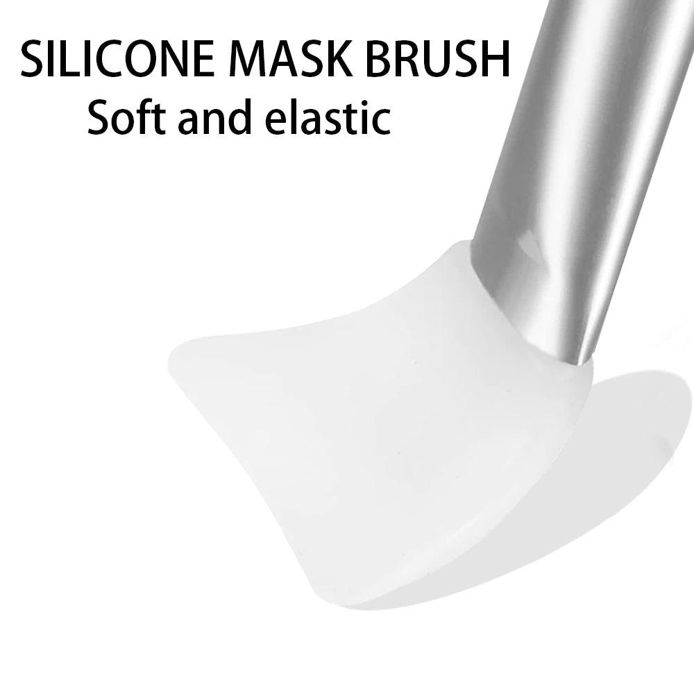 White, flexible silicone face mask spatula with a smooth, curved blade and a metallic handle.