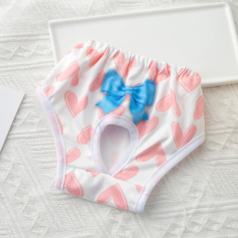 Washable dog diaper with pink heart pattern and blue bow for female pets, reusable sanitary pants for heat protection.