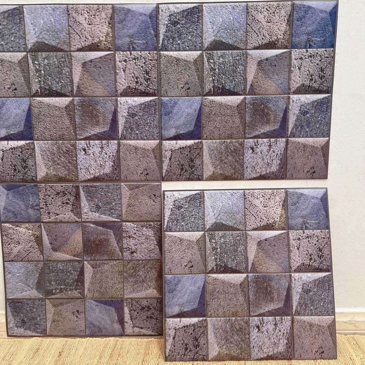Concrete-look square peel-and-stick backsplash tiles with gray and dark blue cube pattern (12 in x 12 in).