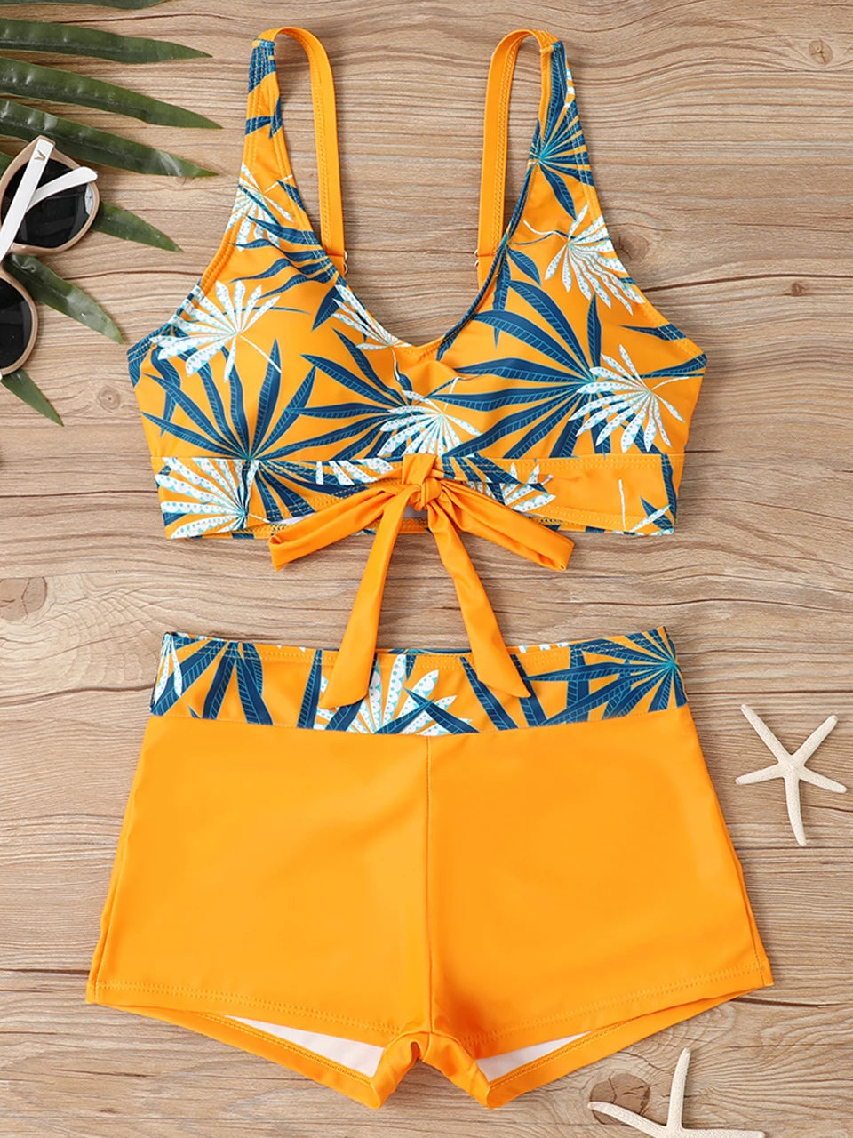 Tidesmit orange high-waist bikini with a blue palm leaf print top, front tie detail, and smooth fabric finish.