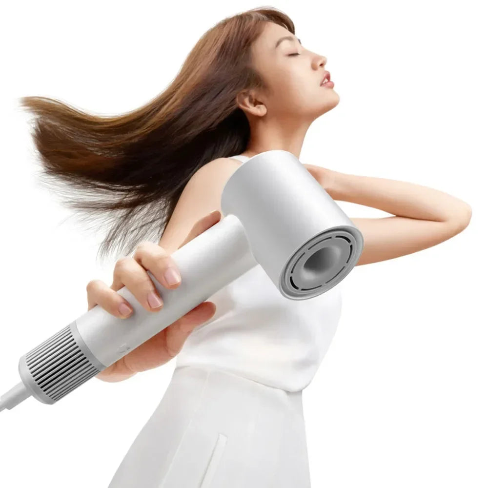 Woman using white MIJIA H501SE high-speed hair dryer for fast professional drying with ionic hair care technology.
