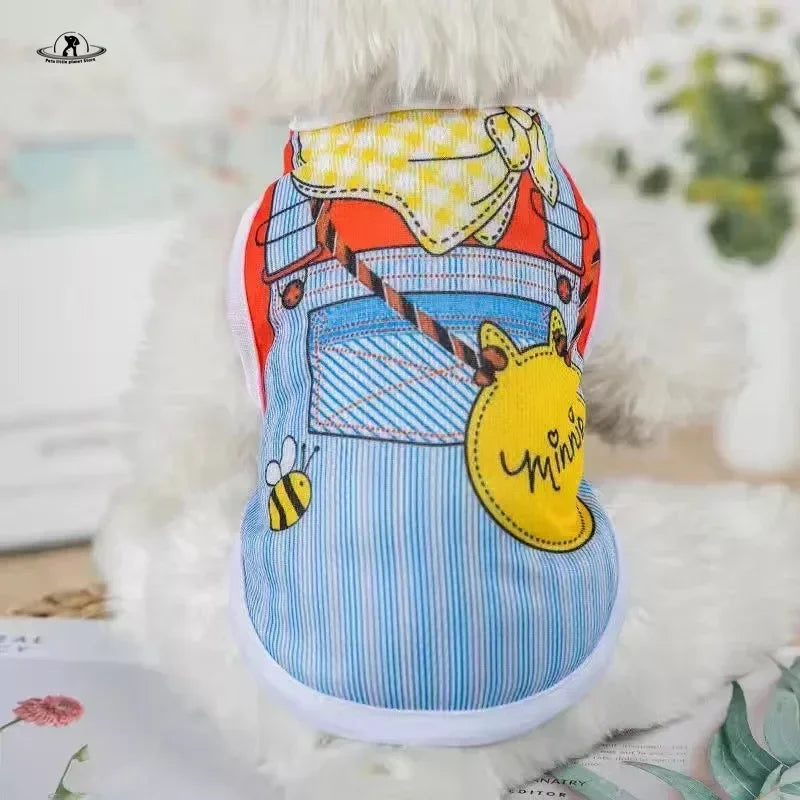 Small dog wearing a cute cartoon overall-style summer vest shirt for breathable, stylish pet comfort.