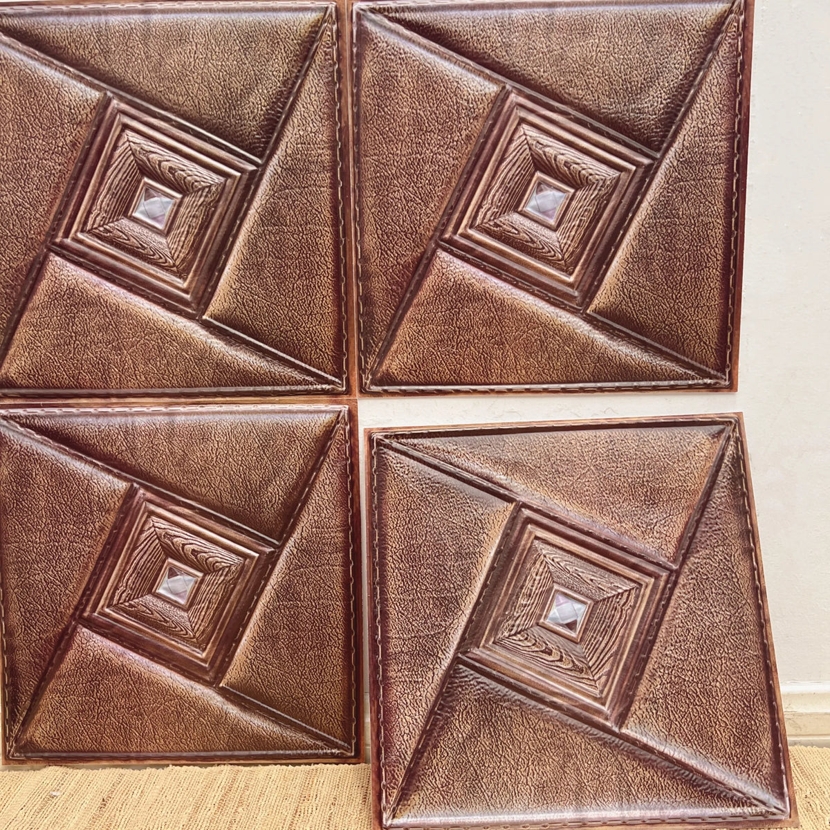 Leather-look peel-and-stick tile backsplash squares in warm brown with embossed frame details