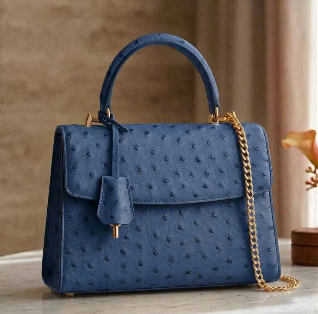 Blue genuine ostrich leather designer handbag with a gold chain strap, top handle, and vintage classic aesthetic.