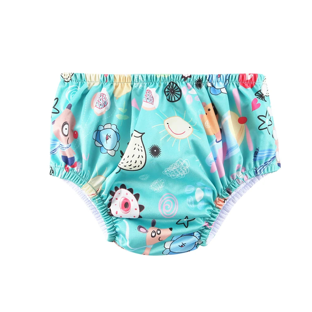 Reusable cloth baby swim diaper with teal animal and sun print pattern.