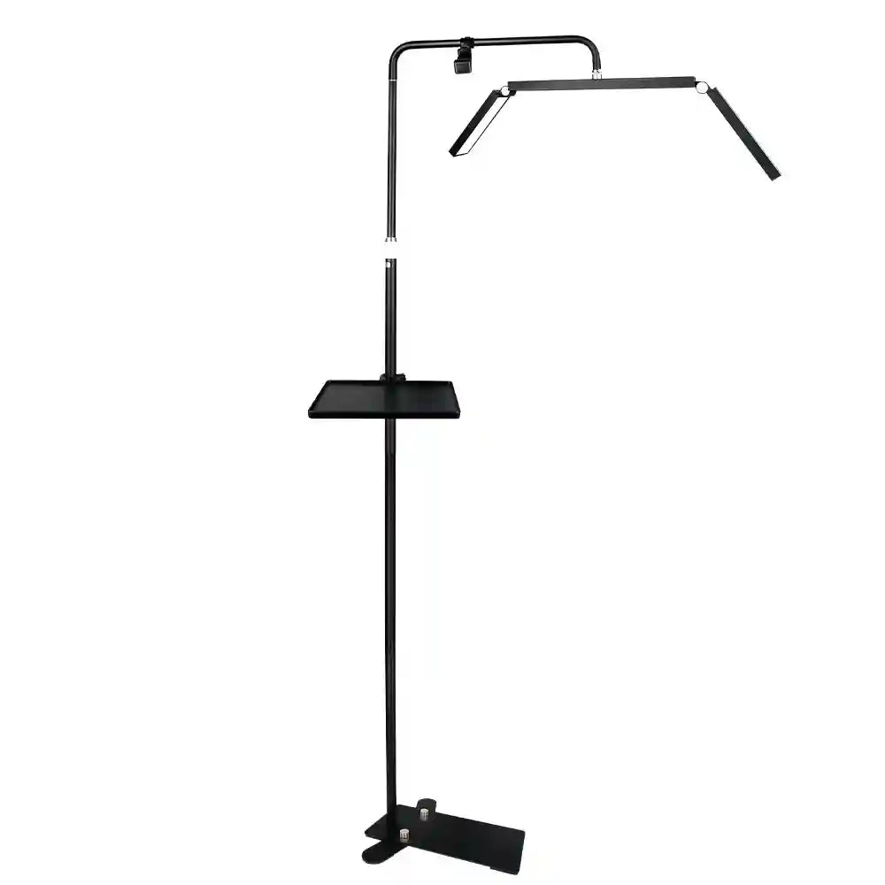 Black floor lamp with an adjustable three-panel light head and attached square tray, used for beauty and salon tasks.
