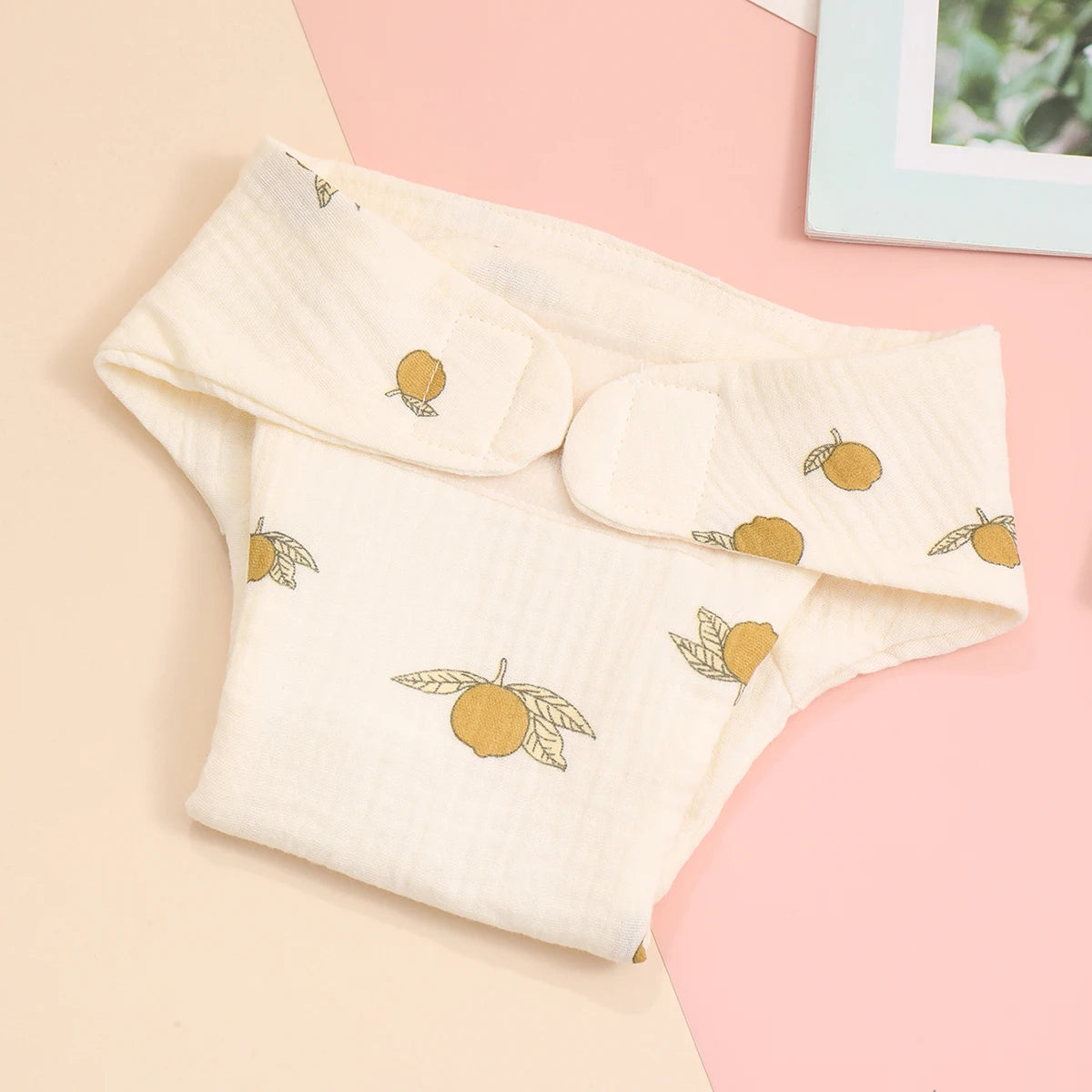 Soft muslin baby diaper with cute yellow citrus fruit print for delicate baby care.