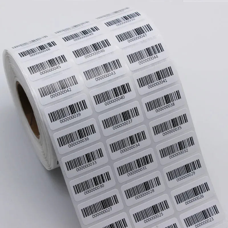 Rolled barcode sticker labels featuring black barcodes and numeric IDs on white backing.