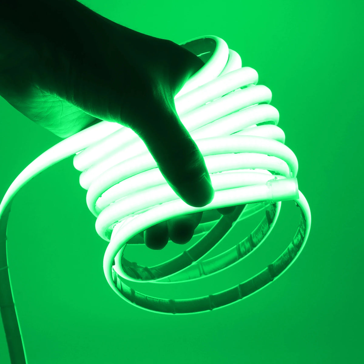 Waterproof COB LED neon strip light glowing green, held in hand