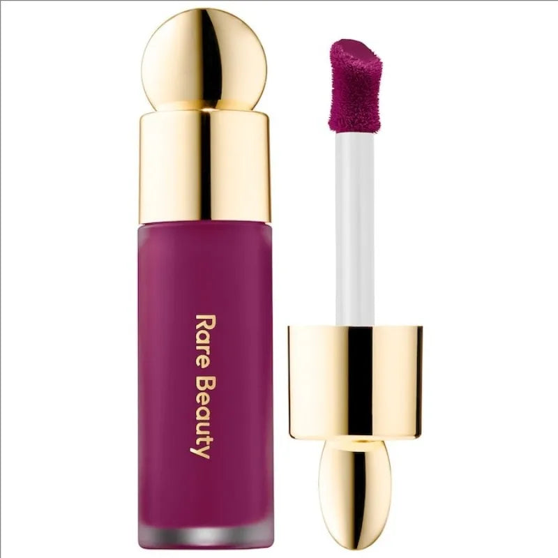 Rare Beauty matte lipstick in rich berry purple with a gold cap and soft applicator for a smooth, moisture-rich finish.
