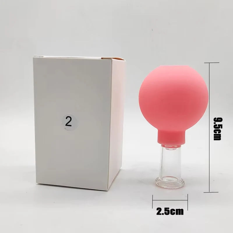 Pink rubber and glass facial cupping tool next to a white box with a "2" label and dimension markers.