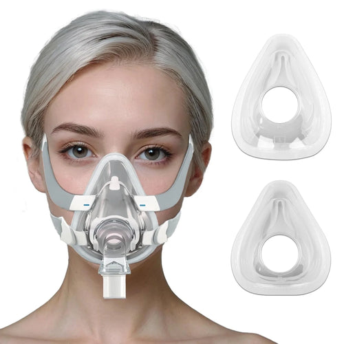 Woman wearing a grey and clear CPAP nasal mask for sleep apnea, featuring replaceable clear silicone cushion inserts.