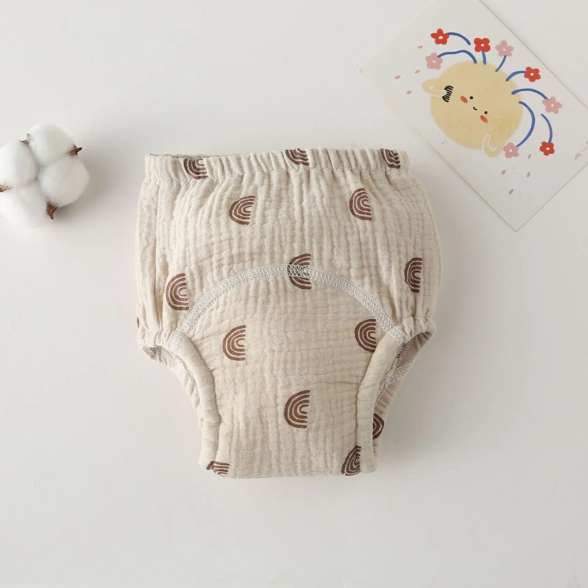 Beige muslin baby training diaper with brown rainbow print for comfortable potty training.