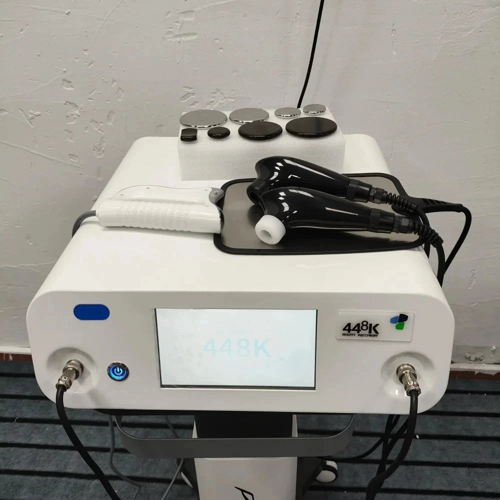 448K beauty machine with white base, touchscreen, black ergonomic handpieces, and metal applicator attachments.