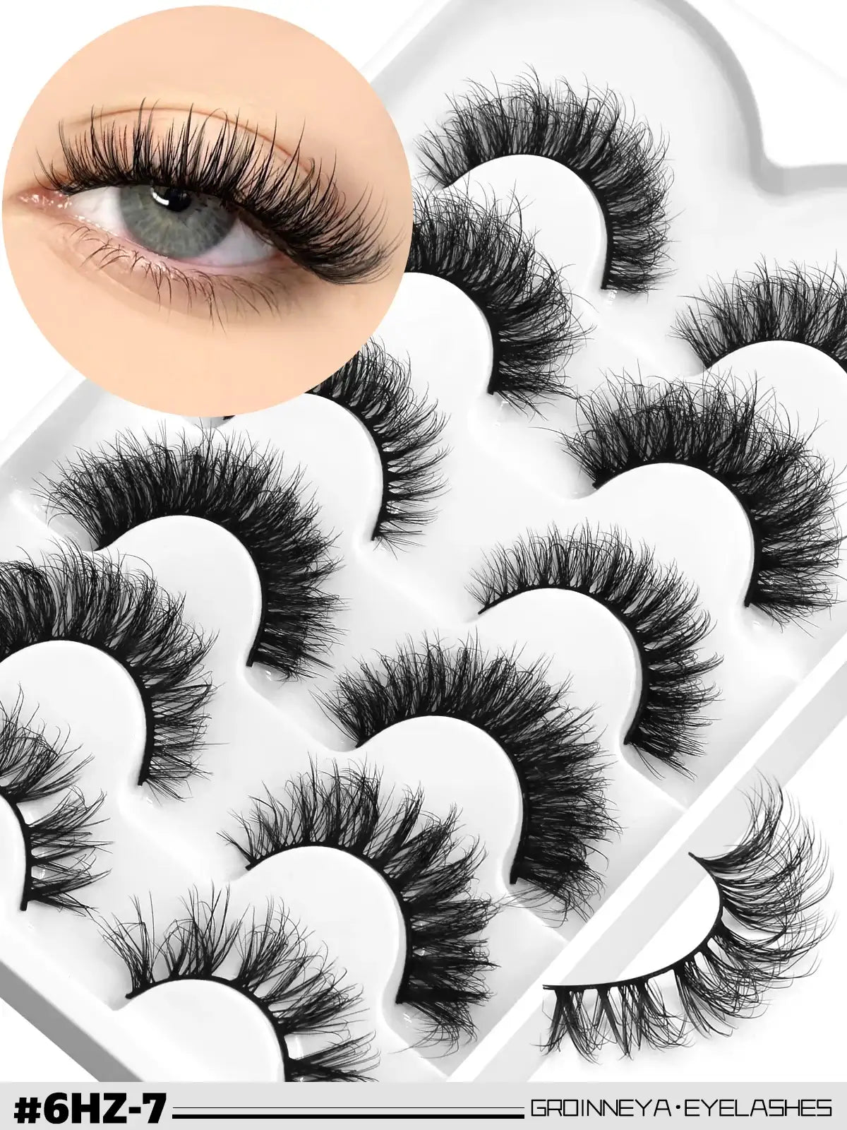 Pack of black, fluffy 3D faux mink cat-eye lashes with a wispy, feathery volume and flexible band on a white tray.