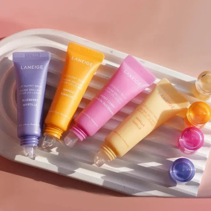 Laneige Lip Glowy Balm set in blueberry, mango, sweet candy, and vanilla, featuring moisturizing, glossy tube applicators.