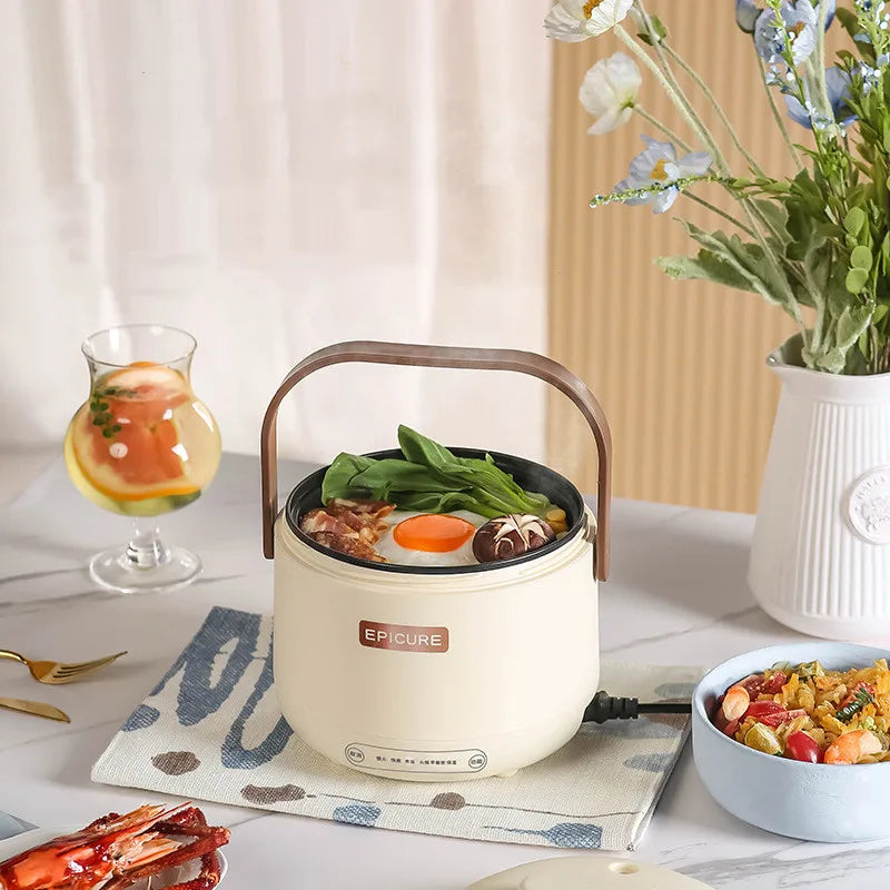 White mini electric cooking pot with brown handle, lid open, meal inside.