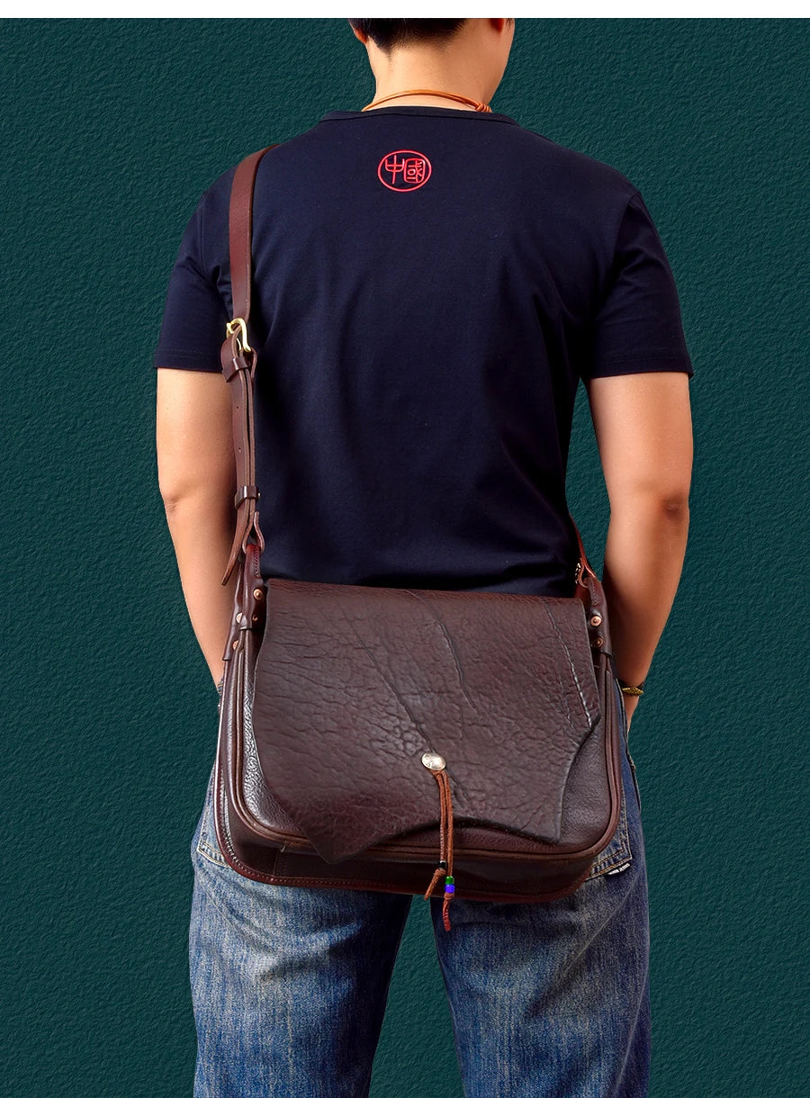 PNDME vintage dark brown cowhide leather messenger bag with flap closure and adjustable shoulder strap.