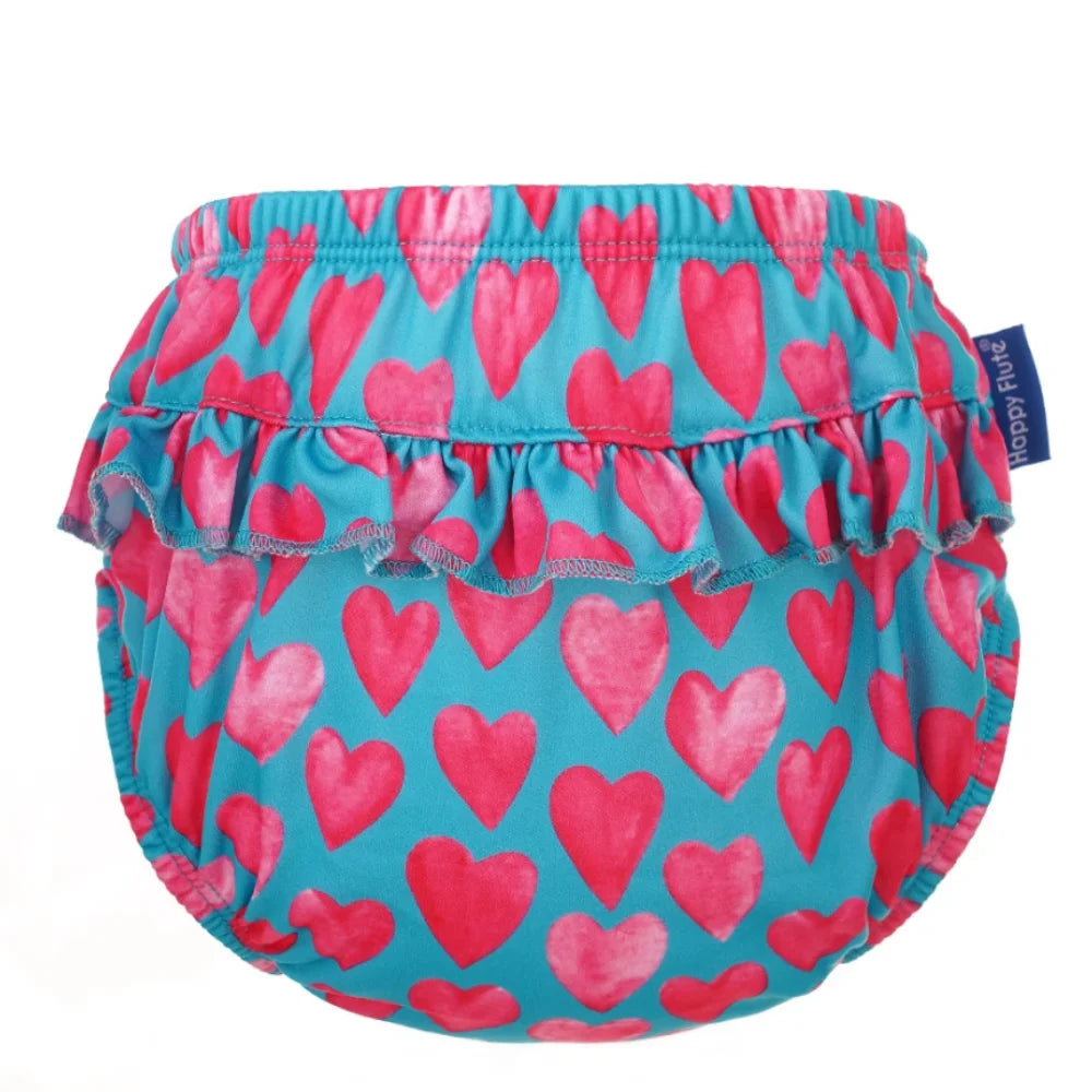 Happy Flute baby cloth diaper cover with pink heart pattern and frilled ruffle trim on teal blue fabric.