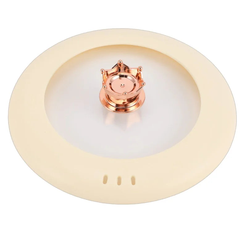 Electric cooking pot lid with rose-gold central handle on cream inner base