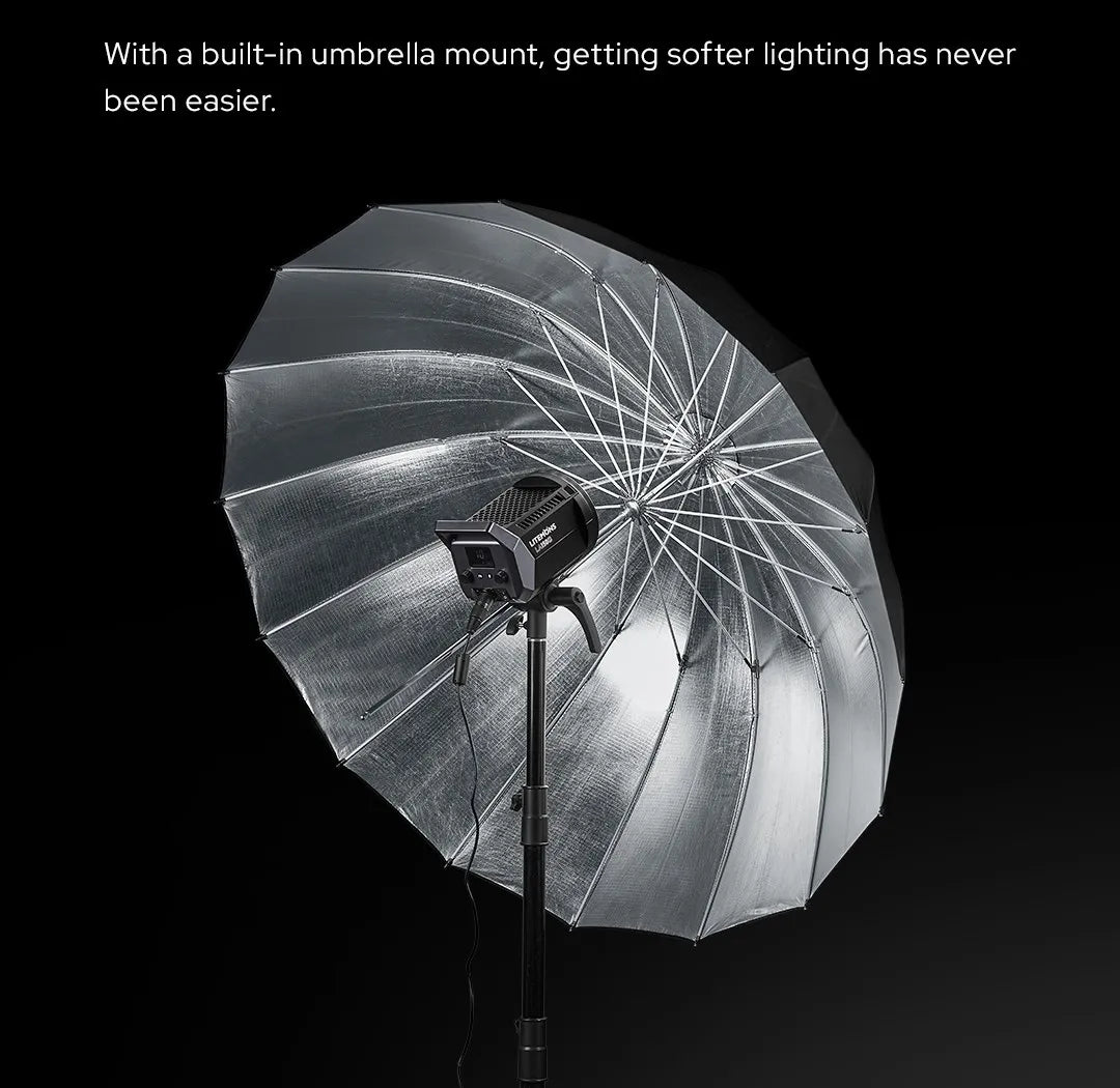 Studio LED video light mounted on a stand with a large, silver, reflective photographic umbrella for soft lighting.