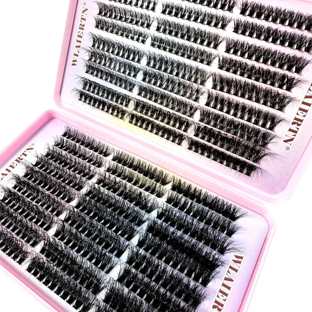Rows of black individual false eyelash clusters arranged in a two-part pink plastic storage tray for beauty use.