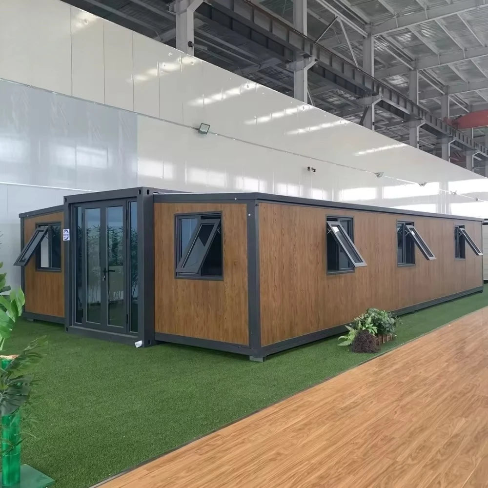 Steel prefab container house with wood siding panels, dark windows, and covered entry