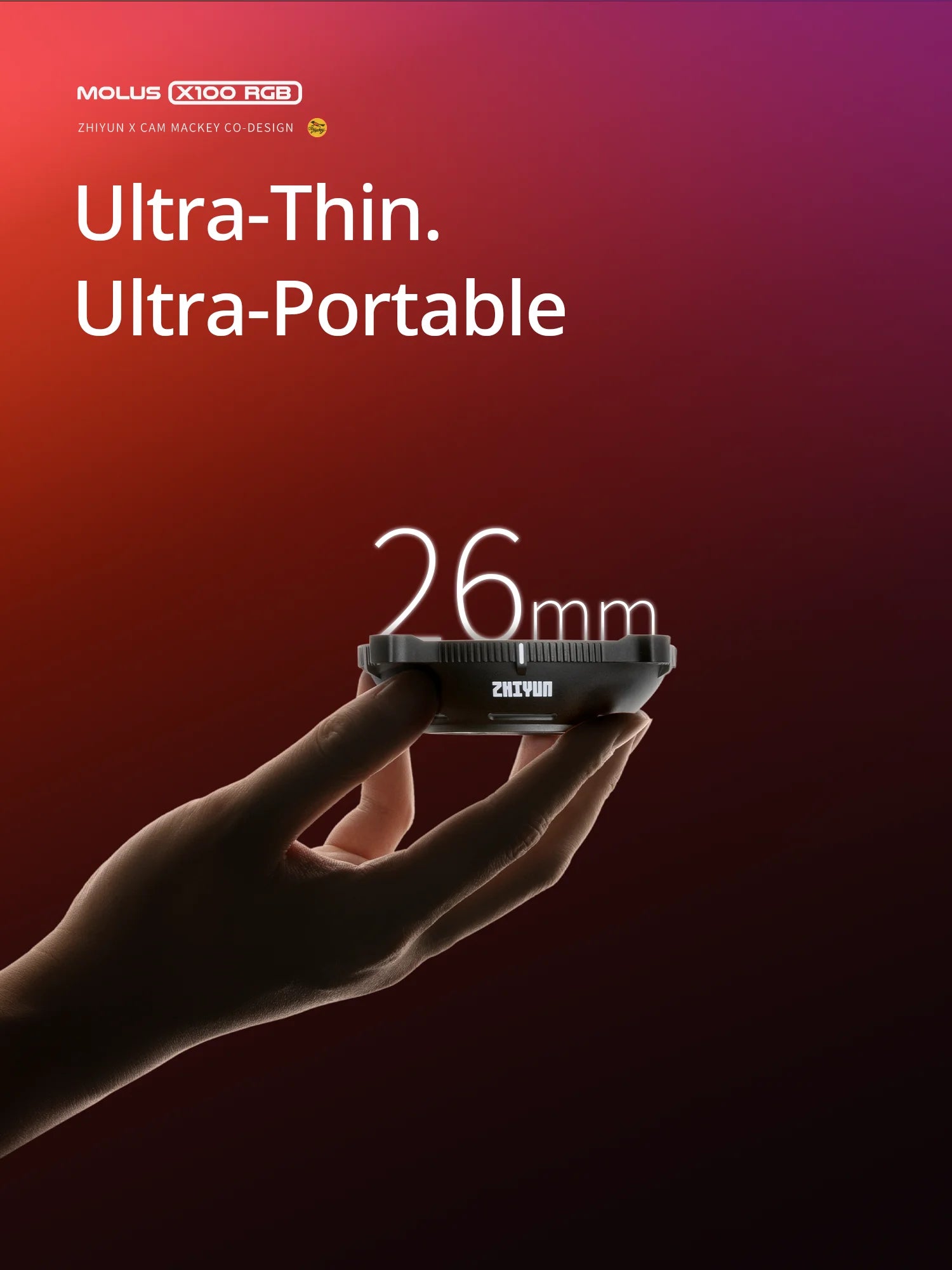 A hand holds a thin, 26mm black round portable lighting accessory against a red and purple gradient background.