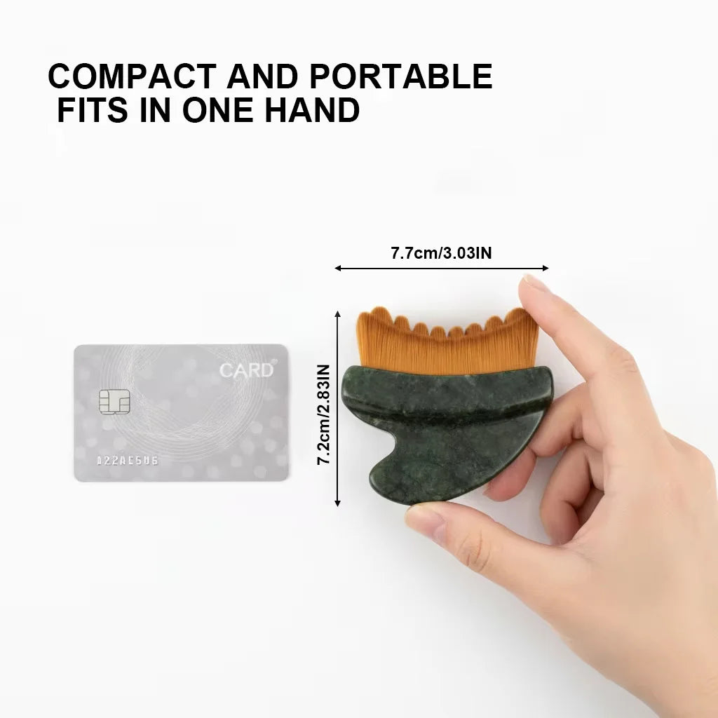 A hand holds a compact, dark green jade gua sha face brush with brown, scalloped-edge bristles, next to a credit card.