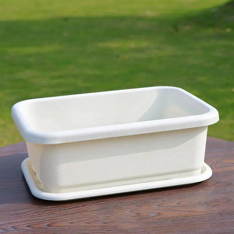 White rectangular planter pot with low profile tray on wooden surface