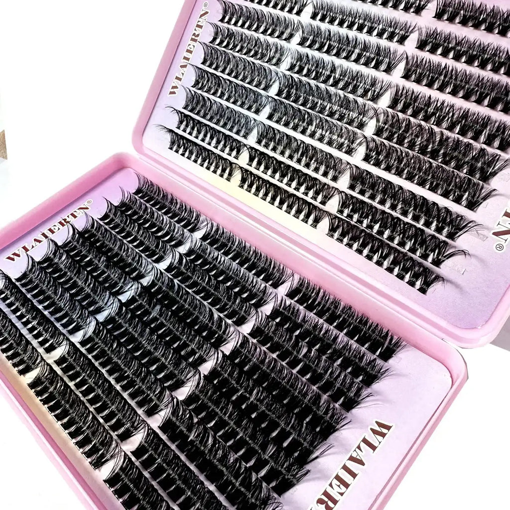 Pink tray containing many rows of individual black synthetic lash clusters for professional eyelash extensions.