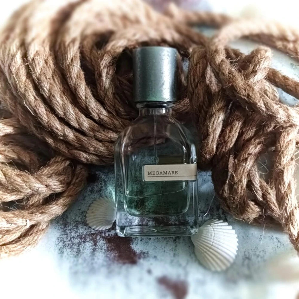 Megamare unisex perfume in square 50ml bottle. Oriental woody, warm amber, musk, and earthy notes. Long-lasting scent.