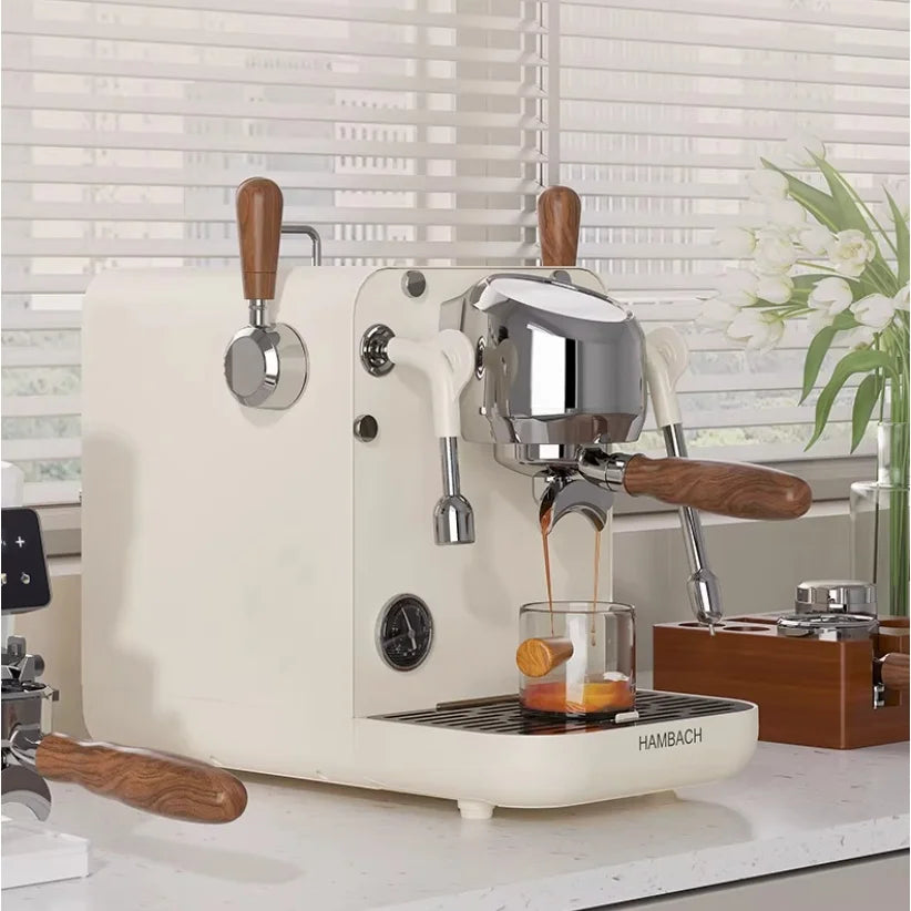 Hambach espresso machine in matte white with wood accents and chrome group head pouring coffee into a glass cup.