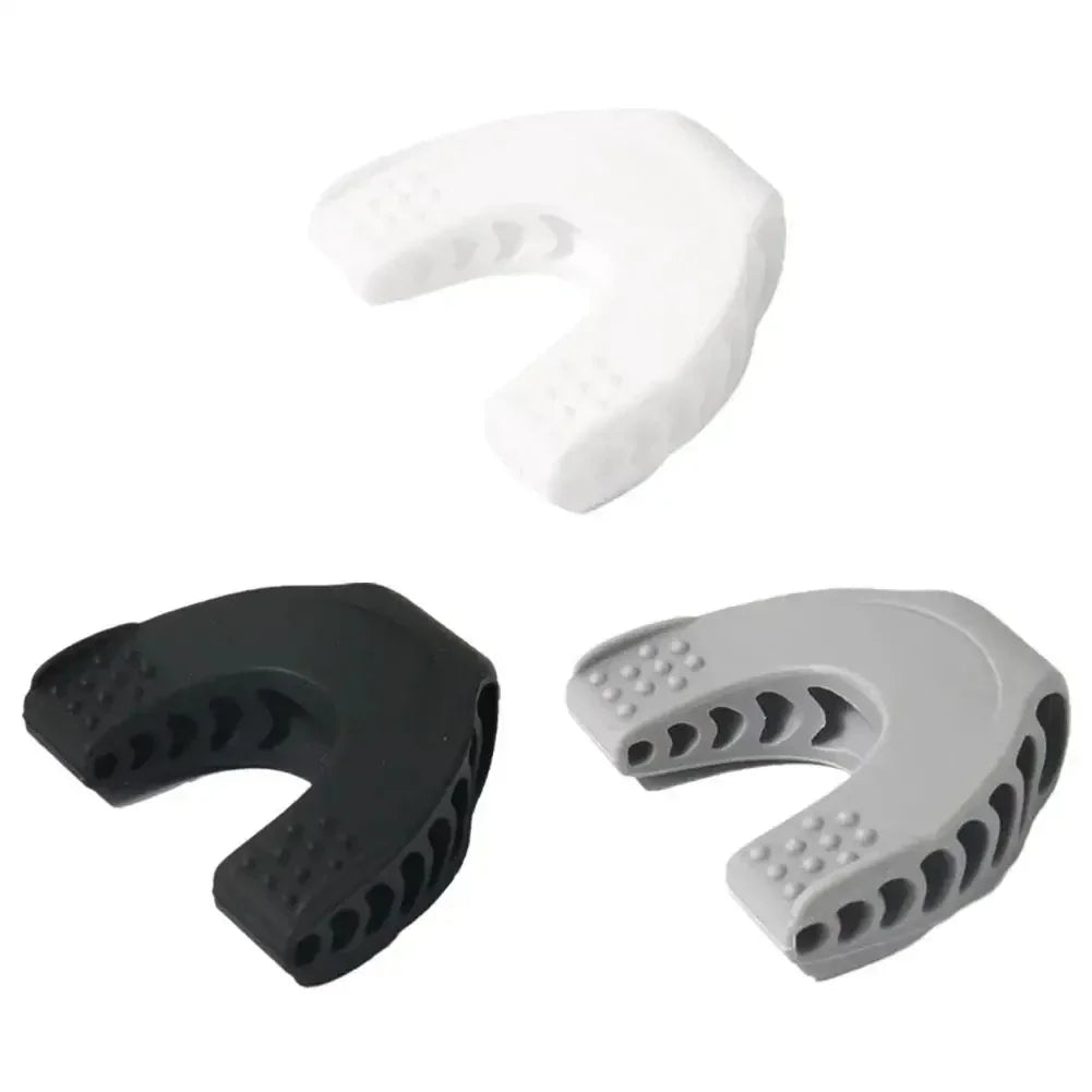 Three horseshoe-shaped silicone jaw exercisers in white, black, and grey, featuring textured bite pads.