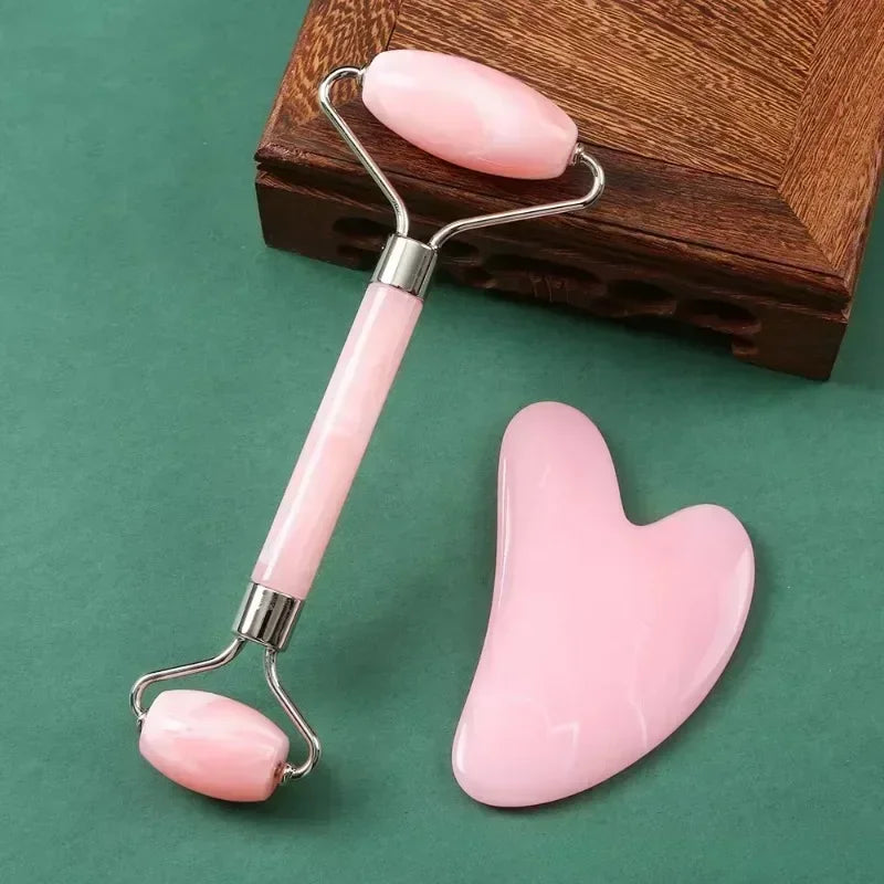 Pink resin facial jade roller and heart-shaped Gua Sha scraper set for anti-aging skin massage and face lifting.