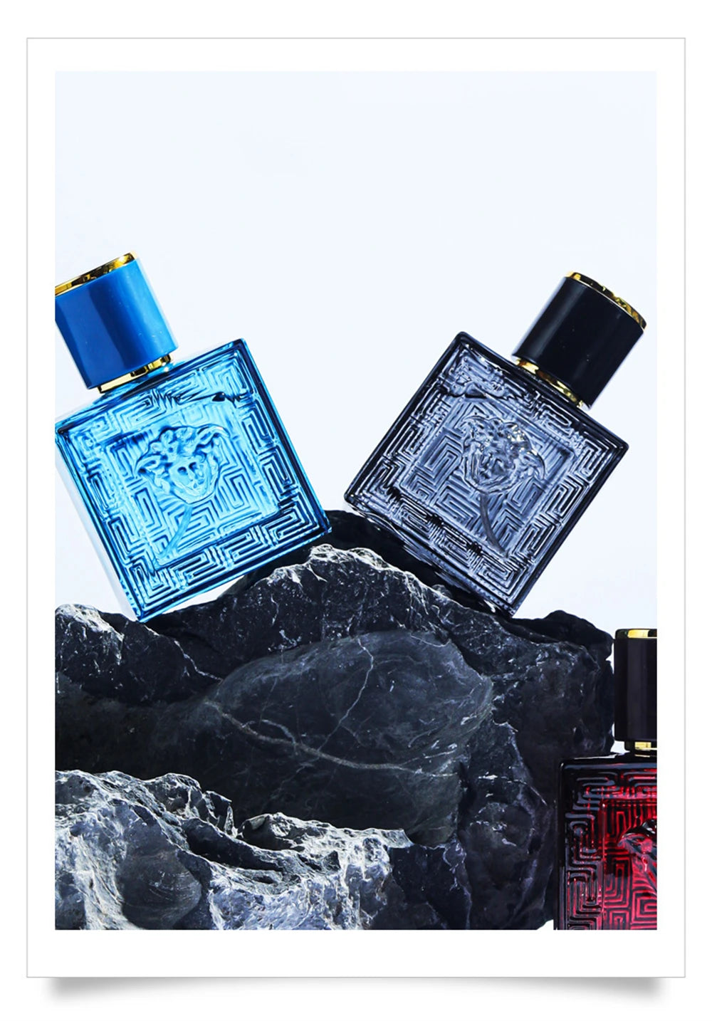 Versace Eros men’s perfume 3pc set: square glass bottles with Medusa emblem on rocks. Lasting cologne gift for men.