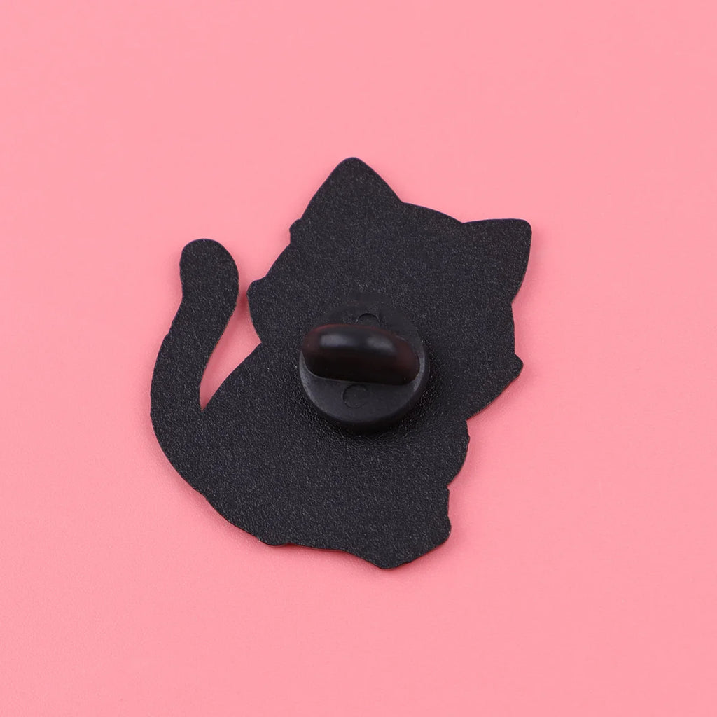 Back view of a black cat enamel pin with a secure clutch, perfect for decorating backpacks or clothes.