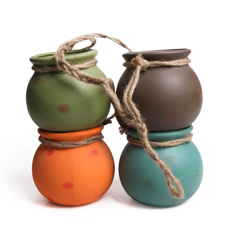 Four-piece ceramic hanging flowerpots set in green, brown, orange, and teal with rope