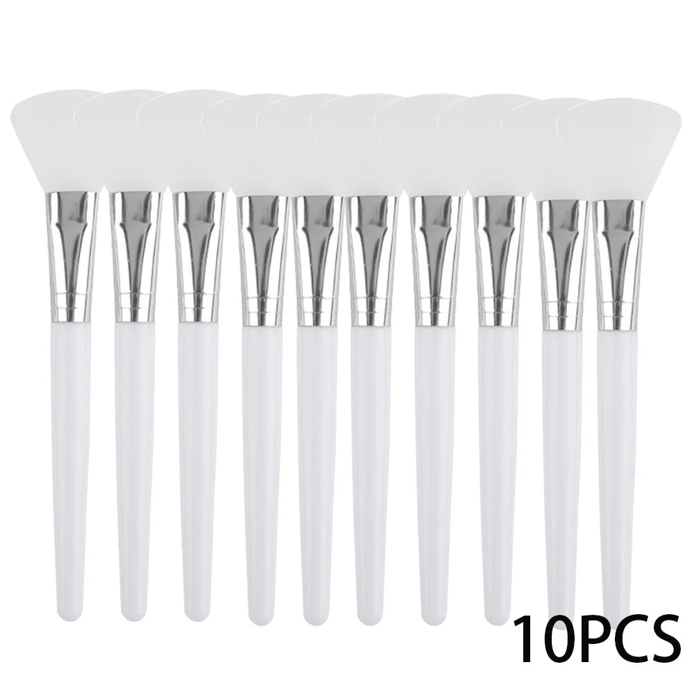 A set of 10 white silicone facial mask brushes with silver ferrules and white handles arranged in a row.