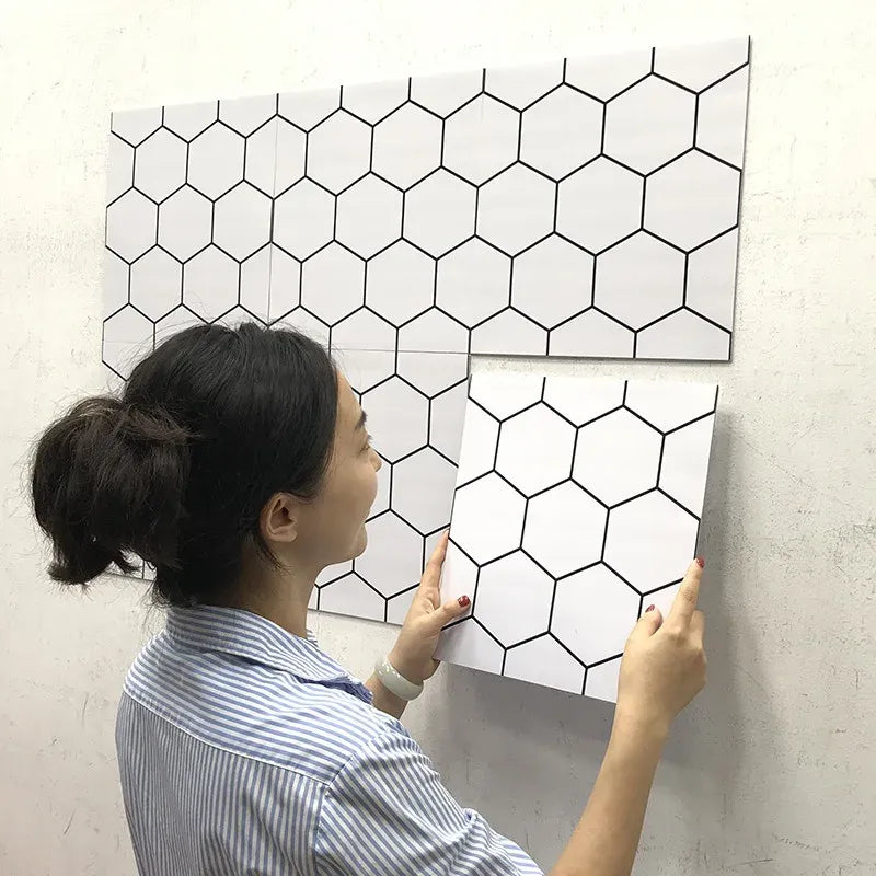 Peel-and-stick tile backsplash sheet with white hexagon pattern and black outlines