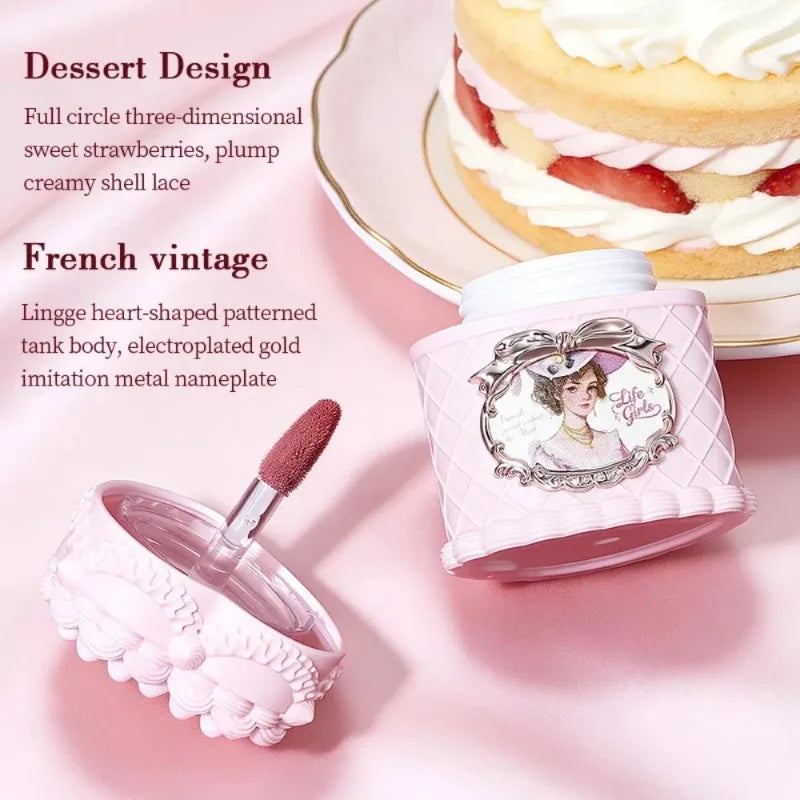 Vintage-style matte velvet mousse lip mud in a pink strawberry cake-themed jar with a gold-trimmed portrait design.