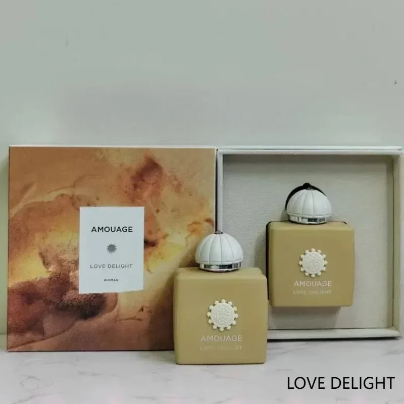 Amouage Love Delight perfume bottles with matte beige finish and white dome caps, presented in a decorative gift box.