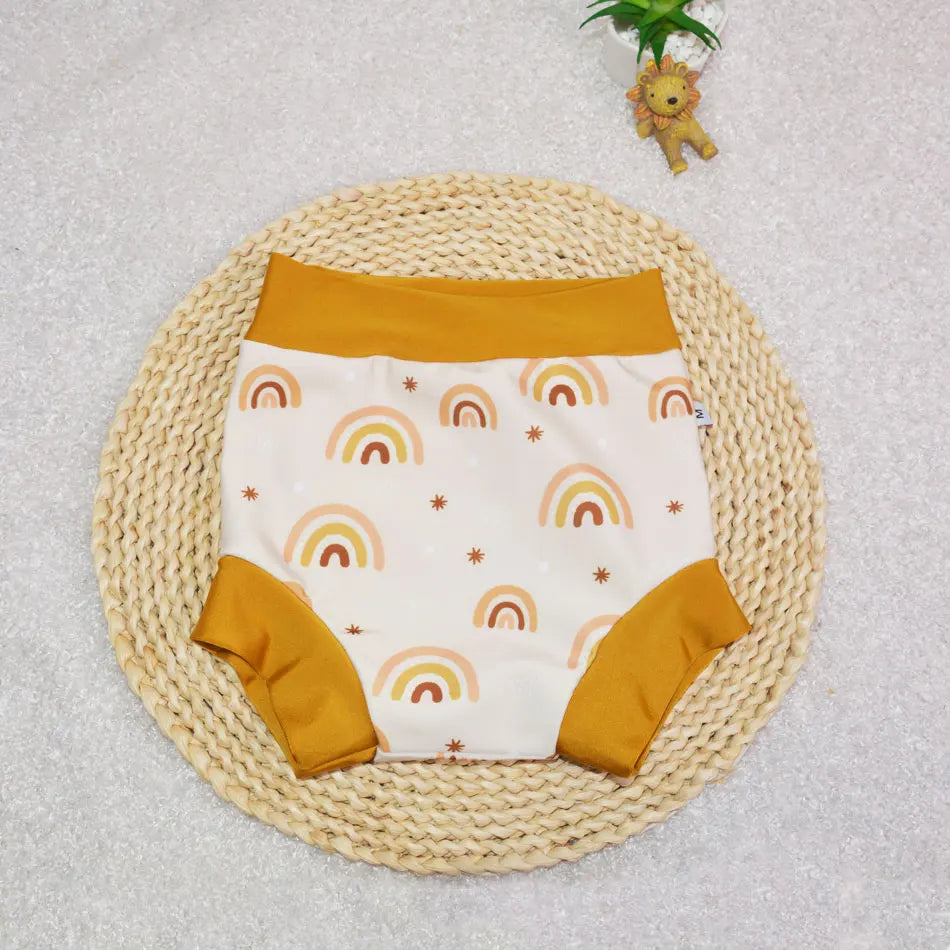 Baby care reusable cloth diaper, size M, featuring a cute cream and mustard rainbow star print design.