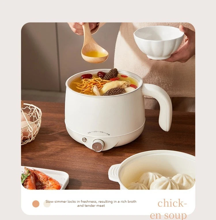 White electric hot pot on wooden table, steaming chicken soup being served