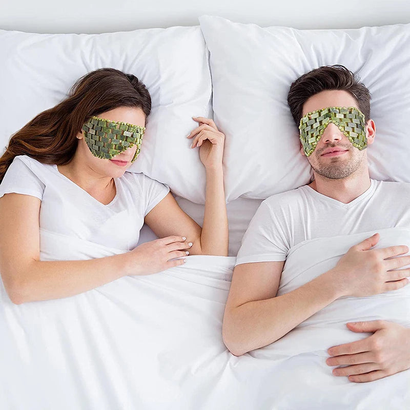Couple sleeping in bed wearing green natural jade stone eye masks for cooling relaxation and skincare therapy.