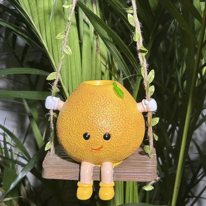 Mini hanging succulent planter, yellow character face with legs, holding a small plant on ropes.