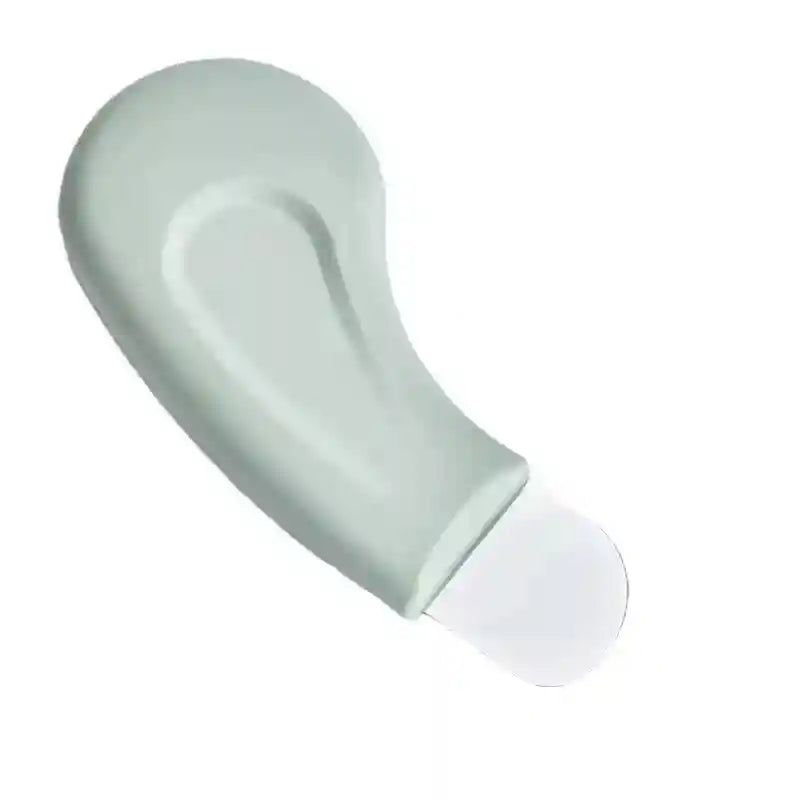 Sage green curved skincare tool for blackhead removal with a flat, rounded metal spatula tip on a white background.